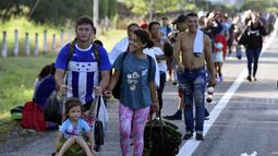 Migrantes llegan a pie a Huehuetán, México, el martes 31 de octubre de 2023, en su camino hacia la frontera con Estados Unidos. Los migrantes dicen que han solicitado permisos temporales de tránsito en Tapachula pero no los consiguieron, algunos después de esperar hasta dos meses, y continuaron su camino sin documentación porque no podían seguir pagando ni la comida ni el alojamiento. (AP Foto/Édgar Clemente)