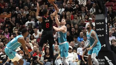 Jamal Cain (8), del Heat de Miami, dispara sobre Gordon Hayward (20), de los Hornets de Charlotte, durante la segunda mitad del juego de baloncesto de la NBA, el miércoles 13 de diciembre de 2023, en Miami. (AP Foto/Lynne Sladky)