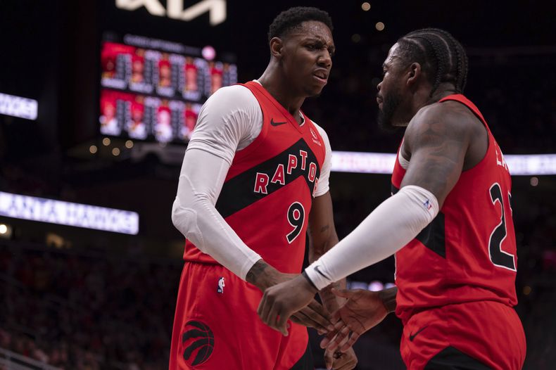 RJ Barrett (9), base de los Raptors de Toronto, festeja con su compañero Jamal Shead (23), durante el encuentro ante los Hawks de Atlanta, el sábado 25 de enero de 2025 (AP Foto/Kathryn Skeean)