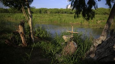 Una cruz marca un monumento funerario en las márgenes del río Bravo _Rio Grande en inglés_ en la frontera de México con Texas, donde muchos migrantes han perdido la vida al intentar cruzar, el jueves 27 de junio de 2019, en Matamoros, estado de Tamaulipas. (AP Foto/Rebecca Blackwell)