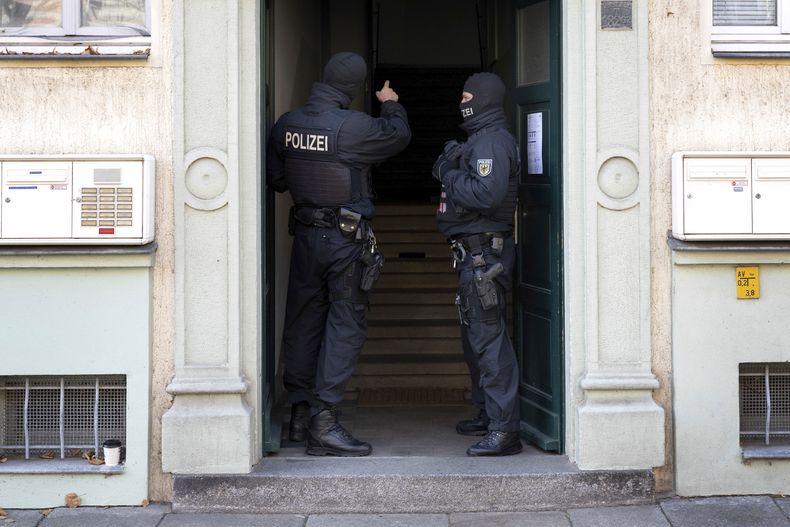 Agentes de policía se ven en la entrada de un edificio durante un cateo en una operación contra supuestos miembros de una organización armada de ultraderecha en Dresde, Alemania, el 5 de noviembre de 2024. (Sebastian Kahnert/dpa via AP)