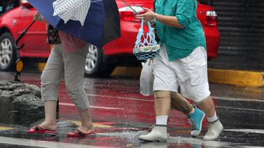 americateve | Ante los efectos del tif&oacute;n Fitow, mujeres llevan sus sombrillas, una de &eacute;stas vencida por el viento, en Taipei, Taiw&aacute;n, el domingo 6 de octubre de 2013. (AP Foto/Chiang Ying-ying)