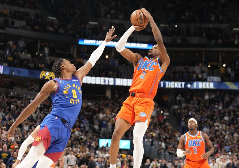 Shai Gilgeous-Alexander, base del Thunder de Oklahoma City, salta para conseguir el enceste del triunfo frente a Peyton Watson, alero de los Nuggets de Denver, el sábado 16 de diciembre de 2023 (AP Foto/David Zalubowski)