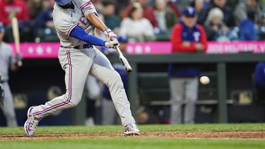 El jugador de los Rangers de Texas Marcus Semien pega un sencillo para romper un juego perfecto del pitcher abridor de los Marineros de Seattle Logan Gilbert en el séptimo inning de su juego de béisbol el lunes 8 de mayo de 2023 en Seattle. (AP Foto/Lindsey Wasson)