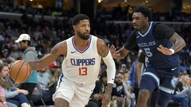 El escolta de los Clippers de Los Ángeles Paul George (13) conduce ante el escolta de los Grizzlies de Memphis Vince Williams Jr. (5) durante la primera mitad del juego de baloncesto de la NBA el viernes 12 de enero de 2024, en Memphis, Tennessee. (AP Foto/Brandon Dill)