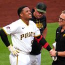 El mánager de los Piratas de Pittsburgh Don Kelly con el pelotero dominicano Esmerlyn Valdez mientras es examinado por el médico tras golpeado por una bola de Merrill Kelly de los Diamondbacks de Arizona el lunes 27 de julio del 2026. (AP Foto/Gene J. Puskar)