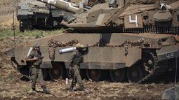 Un soldado israelí carga un proyectil junto a un tanque en el norte de Israel, el 27 de septiembre de 2024. (AP Foto/Baz Ratner)