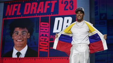 El cornerback Christian Gonzalez parado en el escenario muestra los colores de la bandera de Colombia en su traje tras convertirse en la 17ma selección por parte de los Patriots de Nueva Inglaterra durante el primer día del draft el jueves 27 de abril del 2023. (AP Foto/Jeff Roberson)