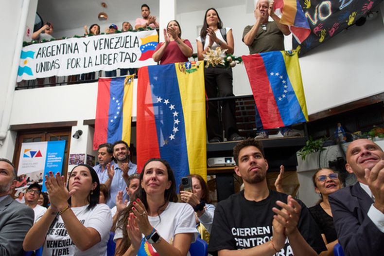 La gente aplaude mientras observa la ceremonia del Premio Nobel de la Paz para la líder opositora venezolana María Corina Machado en Noruega, durante una sesión en directo en Buenos Aires, Argentina, el miércoles 10 de diciembre de 2025. (Foto AP/Rodrigo Abd)