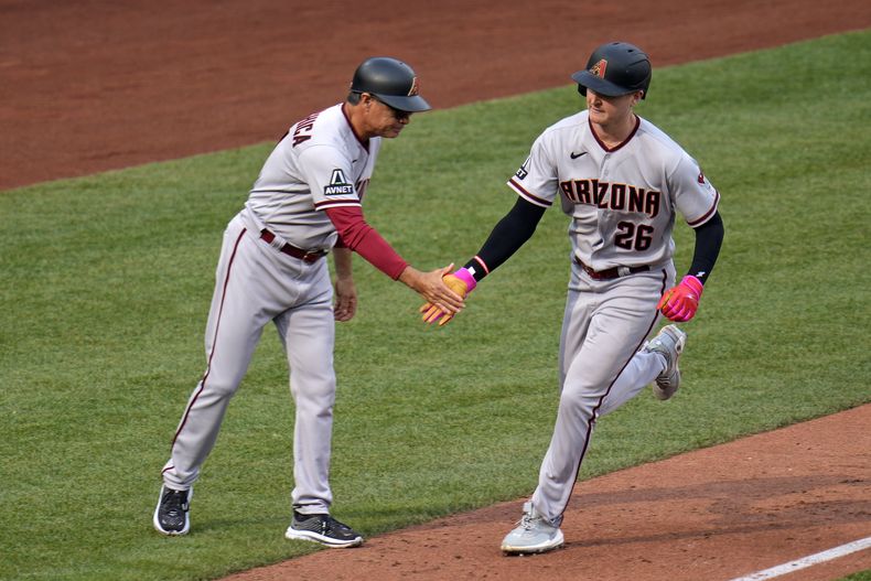 Pavin Smith, de los Diamondbacks de Arizona, recorre la antesala es felicitado por el coach Tony Perezchica, luego de batear un jonrón el sábado 20 de mayo de 2023, ante los Piratas de Pittsburgh (AP Foto/Gene J. Puskar)