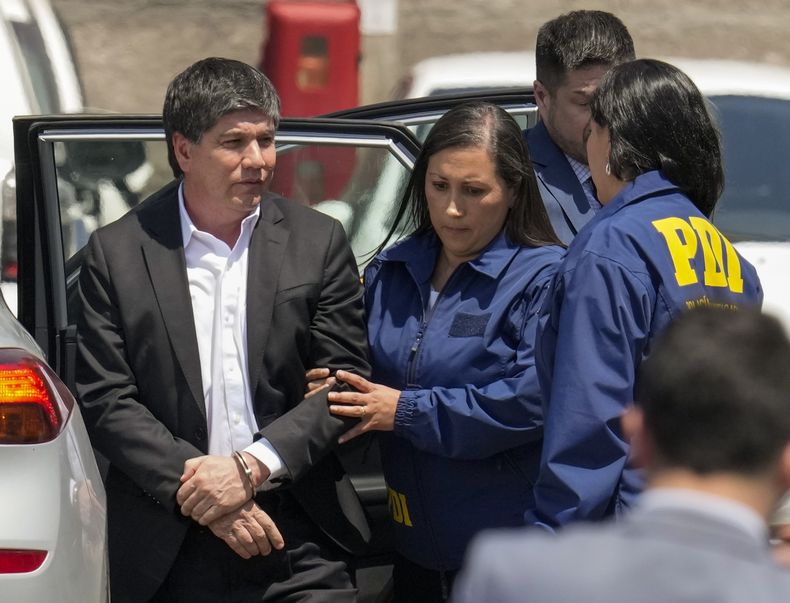 El exsubsecretario de Interior de Chile, Manuel Monsalve, es escoltado por agentes de la Policía de Investigaciones luego de ser arrestado como parte de una investigación sobre una presunta violación de una funcionaria que llevó a su renuncia en Santiago, Chile, el jueves 14 de noviembre de 2024. (AP Foto/Esteban Félix)