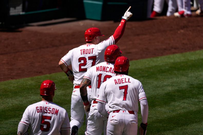 Mike Trout (27), de los Angelinos de Los Ángeles, señala después de anotar con un doble de Nolan Schanuel junto con Yoan Moncada (10) y Jo Adell (7) durante la séptima entrada del juego de béisbol contra los Azulejos de Toronto, el miércoles 22 de abril de 2026, en Anaheim, California. (AP Foto/Mark J. Terrill)