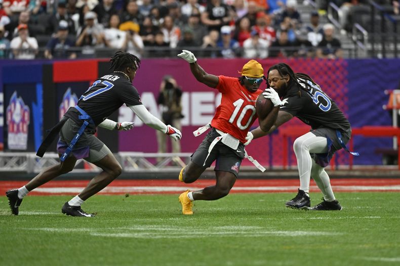 ARCHIVO - El wide receiver Tyreek Hill (10) acarrea el balón ante la marca del cornerback Tariq Woolen (27) y linebacker ZaDarius Smith (55) durante un juego de fútbol bandera durante el Pro Bowl de la NFL, el 5 de febrero de 2023, en Las Vegas. (AP Foto/David Becker)