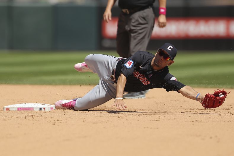 El venezolano de los Guardianes de Cleveland Andrés Giménez se lanza para capturar la bola lanzada por el lanzador abridor Logan Allen durante la cuarta entrada del juego de béisbol ante los Medias Blancas de Chicago, el domingo 12 de mayo de 2024 en Chicago. (AP Foto/Melissa Tamez)