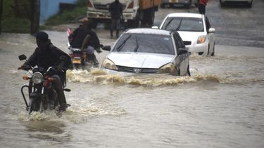 ARCHIVO - Motociclistas y automovilistas avanzan por una calle inundada en la ciudad keniana de Mombasa el viernes 3 de noviembre de 2023, luego de un intenso aguacero. (AP Foto/Gideon Maundu, Archivo)