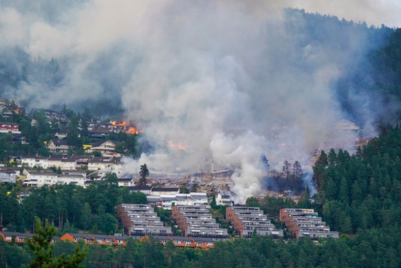 Una nube de humo sale de una zona residencial incendiada en la localidad de Krokstadelva, en Drammen, Noruega, el 17 de julio de 2026. (Thomas Fure/NTB Scanpix via AP)