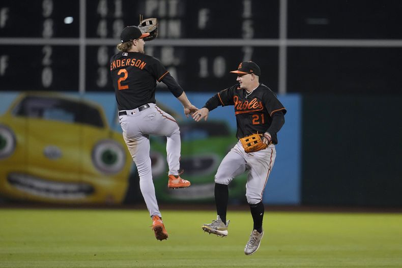 Gunar Henderson y Austin Hays, de los Orioles de Baltimore, festejan la victoria sobre los Atléticos de Oakland, el viernes 18 de agosto de 2023 (AP Foto/Jeff Chiu)