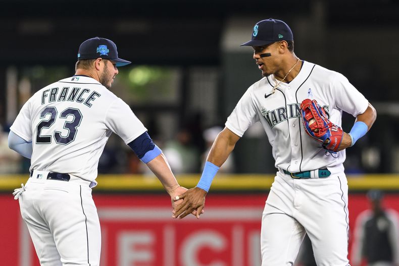El primera base Ty France celebra con Julio Rodríguez el triunfo de los Marineros de Seattle sobre los Medias Blancas de Chicago el domingo 18 de junio del 2023. (AP Foto/Caean Couto)
