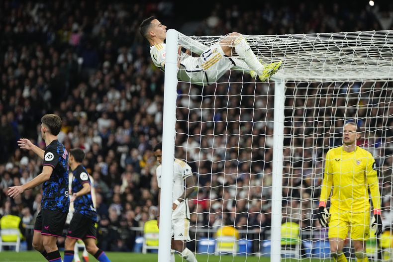Lucas Vázquez del Real Madrid se cuelga del arco durante el partido contra el Sevilla en la Liga de España, el domingo 25 de febrero de 2024, en Madrid. (AP Fto/Manu Fernández)
