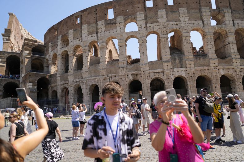 Turistas toman fotos del Coliseo en Roma, martes 27 de junio de 2023. El ministro de Cultura, Gennaro Sangiuliano, prometió hallar y castigar a un turista filmado cuando grababa su nombre y el de su novia en el muro del Coliseo, un delito que se castiga con multas abultadas. El video del incidente se volvió viral en las redes sociales. (AP Foto/Andrew Medichini)
