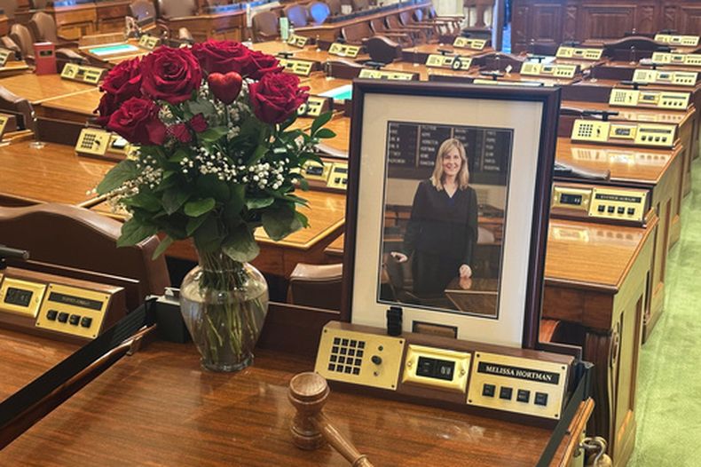 El escritorio de la difunta presidenta de la Cámara de Representantes de Minnesota, Melissa Hortman, permanece vacío en memoria de la legisladora, con excepción de flores, su retrato y un mazo, en la Cámara de Representantes del estado, el miércoles 18 de marzo de 2026, en el Capitolio del estado, en St. Paul, Minnesota. (AP Foto/Steve Karnowski)