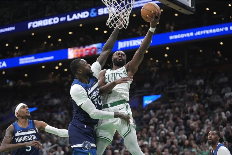 Jaylen Brown, con el balón, de los Celtics de Boston, ataca el aro con Julius Randle (30), de los Timberwolves de Minnesota, intentendo bloquear su tiro durante la segunda mitad del juego de baloncesto de la NBA, el domingo 24 de noviembre de 2024, en Boston. (AP Foto/Steven Senne)