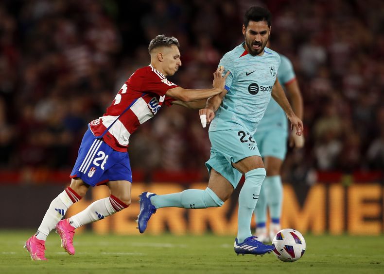ARCHIVO - Bryan Zaragoza del Granada empuja a Ilkay Gundogan del Barcelona durante un partido de la Liga de España, el 8 de octubre de 2023. (AP Foto/Fermín Rodríguez)