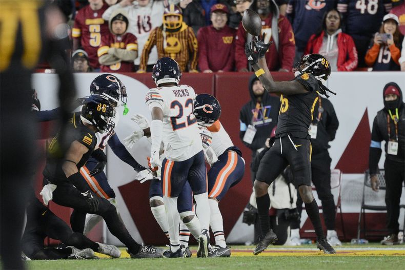 Noah Brown (85), derecha, receptor de los Commanders de Washington, atrapa un pase de anotación de 52 yardas en las diagonales mientras el tiempo expiraba para darle a su equipo una victoria 18-15 sobre los Bears de Chicago en el juego de la NFL del domingo 27 de octubre de 2024, en Landover, Maryland. (AP Foto/Nick Wass)