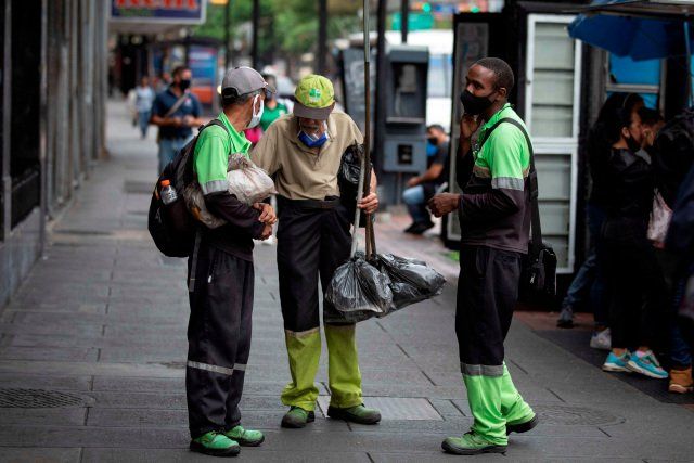 Trabajadores de aseo urbano caminan luego de terminar su turno de trabajo, el 14 de abril de 2021, en Caracas (Venezuela). EFE/RAYNER PEÑA R.