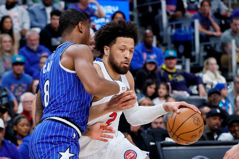 El guardia de los Pistons de Detroit, Cade Cunningham (2), conduce ante el alero de los Magic de Orlando, Jamal Cain (8), durante la primera mitad del Juego 7 de una serie de primera ronda de los playoffs de baloncesto de la NBA, el domingo 3 de mayo de 2026, en Detroit. (Foto AP/Duane Burleson)