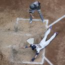 Christian Yelich de los Cerveceros de Milwaukee anota una carrera ante el receptor Jason Delay de los Piratas de Pittsburgh, el domingo 18 de julio de 2023, en Milwaukee. (AP Foto/Morry Gash)