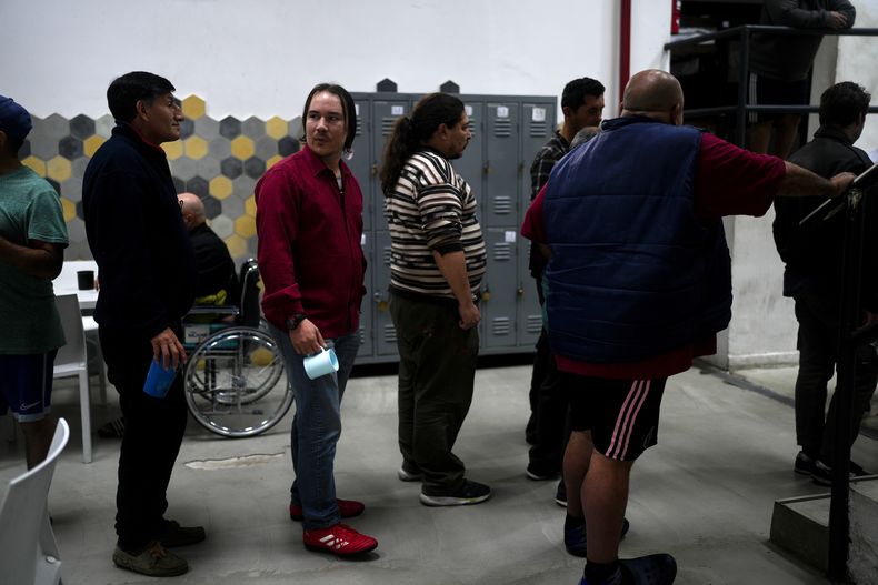 Jonatan, de 26 años, espera en fila a recibir un snack de tarde en el Centro de Inclusión Social Bepo Ghezzi, en el barrio Parque Patricios de Buenos Aires, Argentina, el jueves 21 de septiembre de 2023. Jonatan contó que estaría durmiendo en las calles si no fuera por el albergue gestionado por la alcaldía de la ciudad en el que dispone, además de una cama, ducha caliente y cuatro comidas al día, apoyo psicológico y orientación para su reinserción laboral. (AP Foto/Natacha Pisarenko)