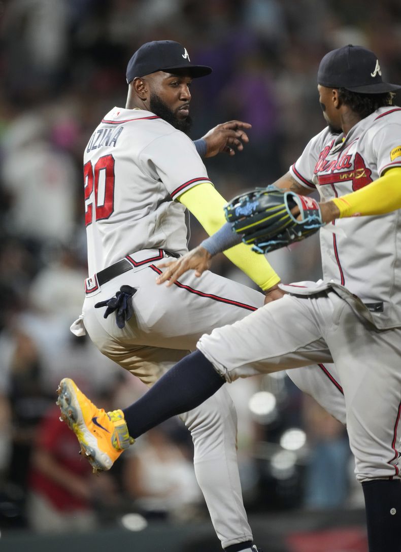 El dominicano Marcell Ozuna, bateador designado de los Bravos de Atlanta, festeja con el venezolano Ronald Acuña Jr., el jardinero derecho, tras el triunfo sobre los Rockies de Colorado, el martes 29 de agosto de 2023 (AP Foto/David Zalubowski)
