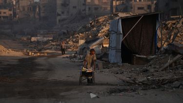 Palestinos caminan entre la destrucción provocada por la ofensiva aérea y terrestre israelí en el vecindario de Sheikh Radwan en Ciudad de Gaza, el miércoles 22 de octubre de 2025. (AP Foto/Abdel Kareem Hana)