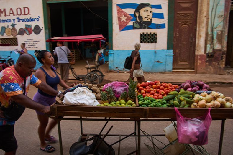 Vendedores ambulantes empujan su carrito de verduras junto a un mural de Fidel Castro en La Habana, Cuba, el miércoles 12 de agosto de 2026. (AP Foto/Ramón Espinosa)