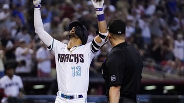 Lourdes Gurriel Jr. (12), de los Diamondbacks de Arizona, celebra su cuadrangular en contra de los Rojos de Cincinnati, mientras el umpire Chris Segal observa durante la séptima entrada del juego de béisbol, el domingo 27 de agosto de 2023, en Phoenix. (AP Foto/Ross D. Franklin)