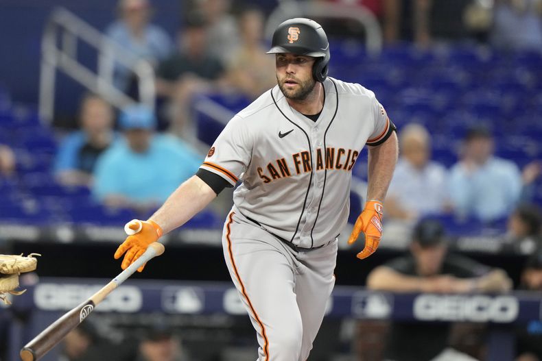 Darin Ruf, de los Gigantes de San Francisco, arroja el bate después de que le concedieran base por bolas en la primera entrada del partido contra los Marlins de Miami, en Miami, el miércoles 19 de abril de 2023. (AP Foto/Lynne Sladky)