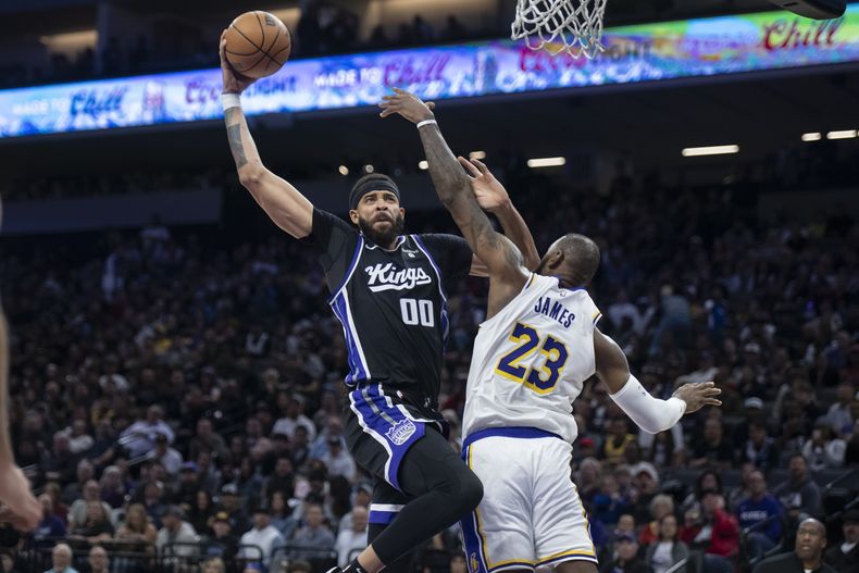 El pívot de los Kings de Sacramento JaVale McGee (00) consigue una clavada frente al alero de los Lakers de Los Ángeles LeBron James (23) en la primera mitad del partido del domingo 29 de octubre de 2023, en Sacramento. (Sara Nevis/The Sacramento Bee via AP)
