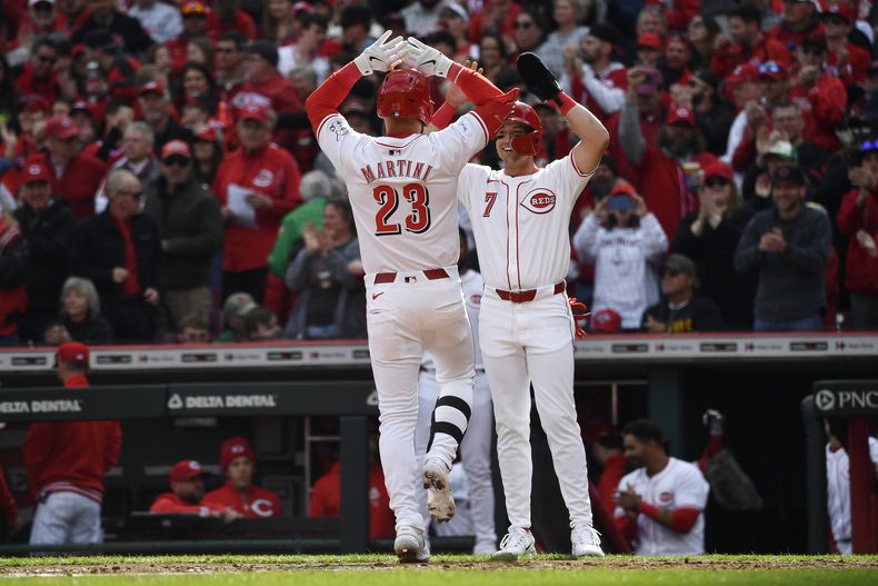 Nick Martini (23), de los Rojos de Cincinnati, recibe felicitaciones de Spencer Steer (7) tras su jonrón de dos carreras durante la segunda entrada del juego de béisbol del día inaugural contra los Nacionales de Washington en Cincinnati, el jueves 28 de marzo de 2024. (AP Foto/Timothy D. Easley)