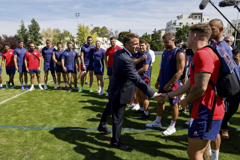 El presidente de Francia Emmanuel Macron (segundo a la derecha) saluda al equipo de Francia en su concentración previo al Mundial de Rugby, en Rueil-Malmaison, el lunes 4 de septiembre de 2023. (Ludovic Marin, Pool vía AP)
