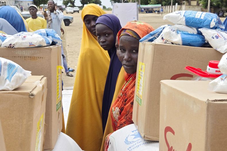 ARCHIVO - Unas personas esperan recibir donaciones de alimentos del Programa Mundial de Alimentos de Naciones Unidas en Damasak, en el noreste de Nigeria, el 6 de octubre de 2024. (AP Foto/Chinedu Asadu, Archivo)