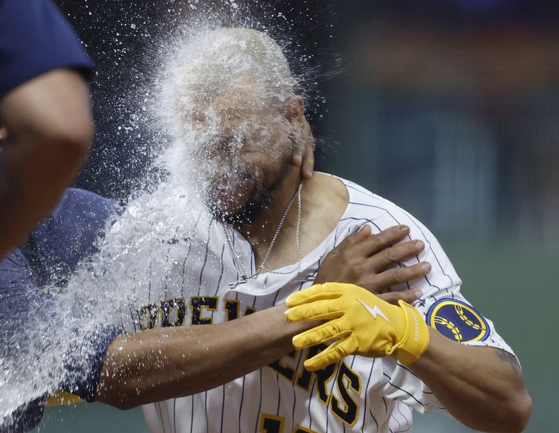 Blake Perkins, de los Cerveceros de Milwaukee, es empapado en la celebración, tras conectar un sencillo decisivo en el décimo inning del juego del sábado 5 de agosto de 2023, ante los Piratas de Pittsburgh (AP Foto/Jeffrey Phelps)