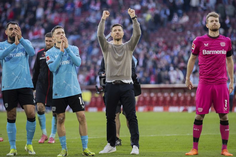 El técnico Xabi Alonso (centro) celebra la victoria de Bayer Leverkusen por 2-0 ante Colonia en la Bundesliga, el domingo 3 de marzo de 2024. (Rolf Vennenbernd/dpa vía AP)