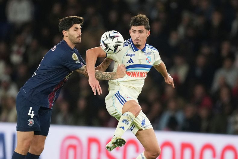 Lucas Beraldo, izquierda, del PSG, y Joaquin Panichelli, del Estrasburgo, disputan un balón durante el partido de fútbol de la Ligue 1 de Francia entre Paris Saint-Germain y Estrasburgo, el viernes 17 de octubre de 2025, en París. (AP Foto/Christophe Ena)