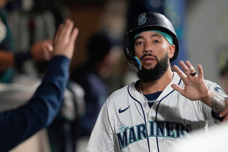 ARCHIVO - J.P. Crawford, de los Marineros de Seattle, celebra en la caseta después de anotar con un sencillo de Josh Naylor durante la cuarta entrada del juego de béisbol de Grandes Ligas ante los Rockies de Colorado el miércoles 24 de septiembre de 2025, en Seattle. (AP Foto/Ryan Sun, Archivo)