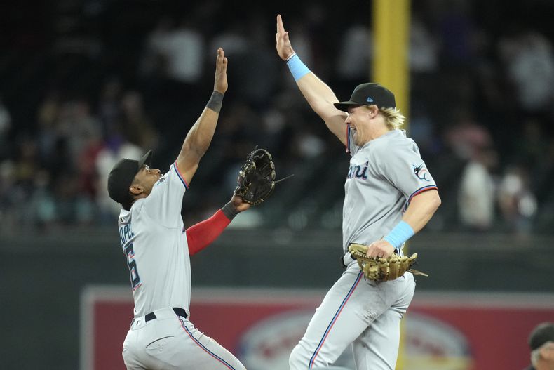 Kyle Stowers, derecha, de los Marlins de Miami, celebra la victoria de su equipo con Otto Lopez (6) en juego de béisbol de Grandes Ligas frente a los Diamondbacks de Arizona, el domingo 29 de junio de 2025, en Phoenix. (AP Foto/Ross D. Franklin)