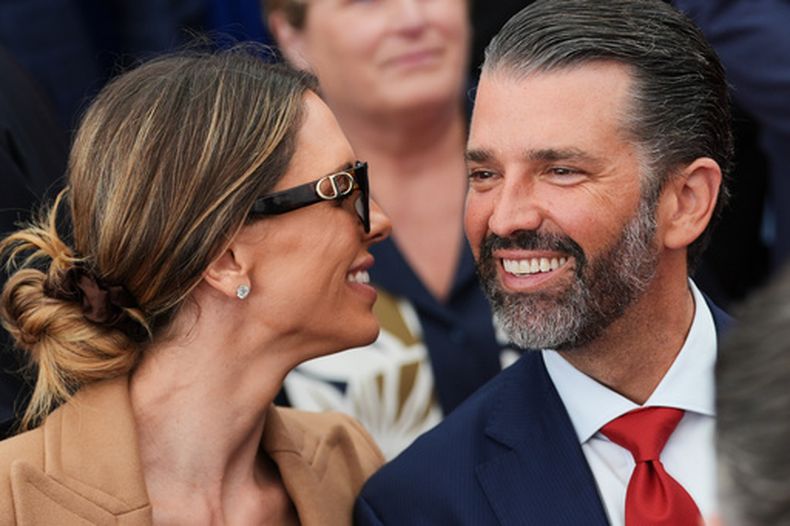 ARCHIVO - Donald Trump Jr., habla con su esposa Bettina, izquierda, mientras esperan que el presidente Donald Trump diga unas palabras al personal de la embajada estadounidense en la residencia Deerfield en Dublín, el 12 de septiembre de 2026. (AP Foto/Julia Demaree Nikhinson, Archivo)