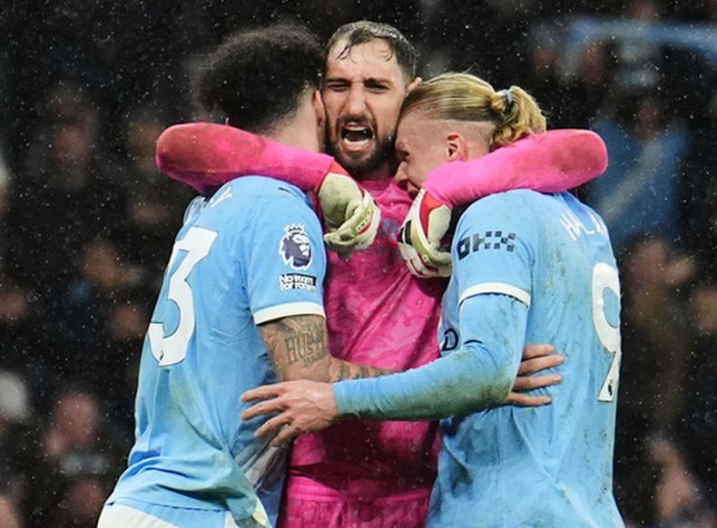 Gianluigi Donnarumma, arquero italiano del Manchester City, abraza a sus compañeros Nico OReilly y Erling Haaland tras el partido ante Newcastle, el sábado 21 de febrero de 2026 (Martin Rickett/PA via AP)