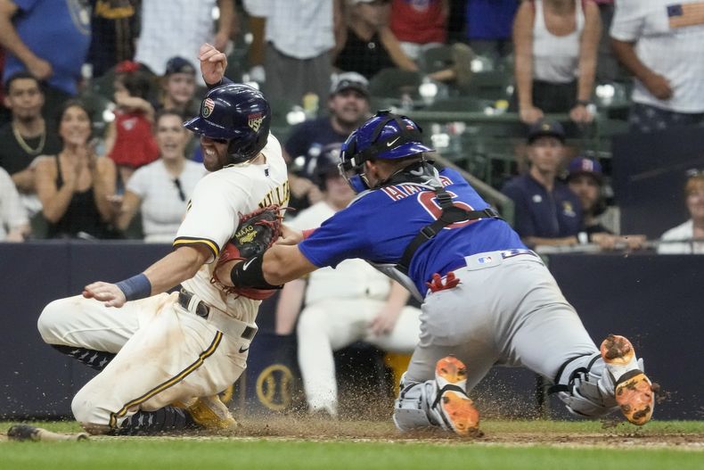 El cátcher de los Cachorros de Chicago Miguel Amaya etiqueta a Owen Miller de los Cerveceros de Milwaukee en la 11ma entrada para terminar el encuentro del martes 4 de julio del 2023. (AP Foto/Morry Gash)