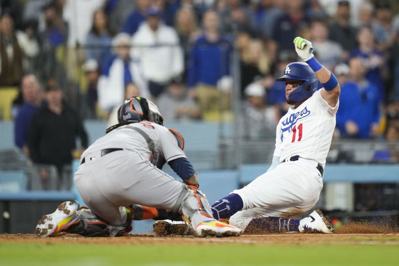 El venezolano Miguel Rojas (11), de los Dodgers de Los Ángeles, es puesto out por el receptor de los Astros de Houston, el puertorriqueño Martín Maldonado, en la cuarta entrada del partido en Los Ángeles, el viernes 23 de junio de 2023. (AP Photo/Jae C. Hong)